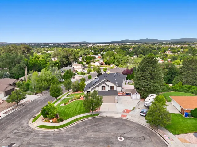 Two-story residence with a multi-car driveway, attached garage, and landscaped front yard