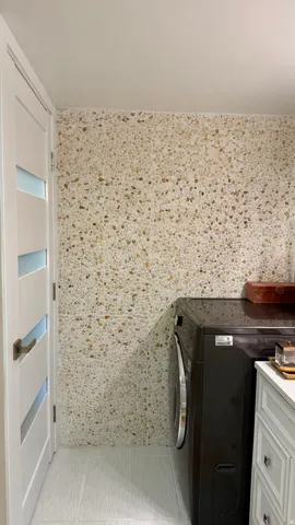 Pebble-finish accent wall with light wood-finish flooring