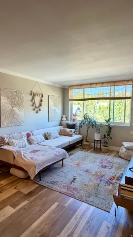 Expansive window with natural light and woven shades, wood-finish flooring, and crown molding