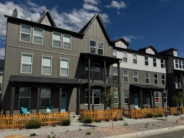 Multi-story exterior with a mix of siding and stucco finishes, featuring prominent gables and multiple windows