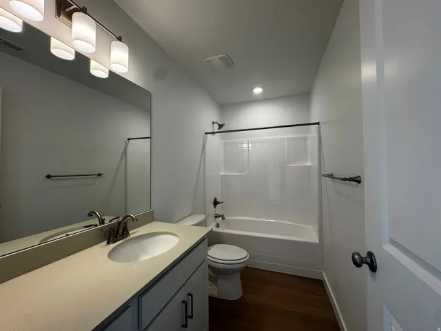 White single vanity with an integrated sink, brushed nickel faucet, and a large wall-mounted mirror