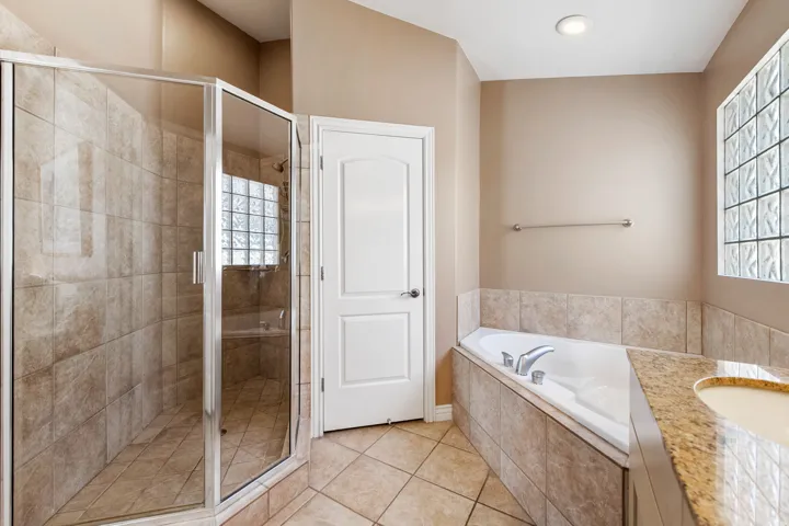Glass-enclosed shower and a vanity with an undermount sink.