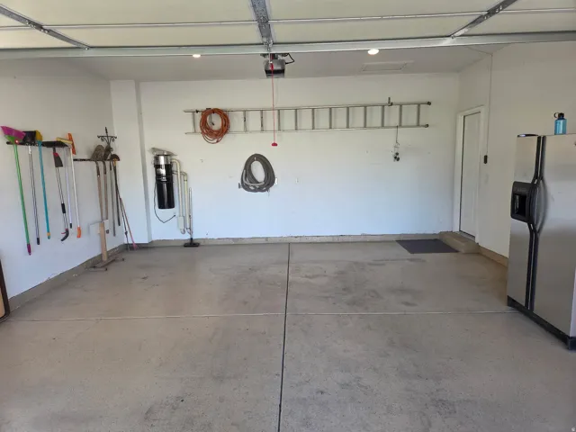 Garage featuring an automatic overhead door, epoxy flooring, and central vac system.