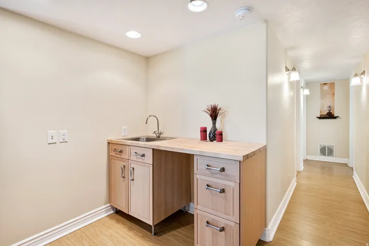 Wet-bar, Integrated utility sink with wood-finish countertop and extra storage below.