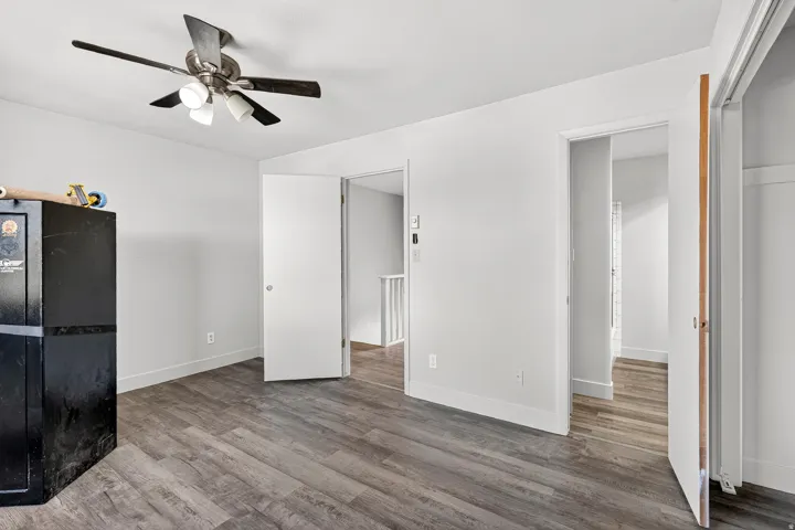 Wood-finish flooring throughout, with a ceiling fan featuring integrated lighting