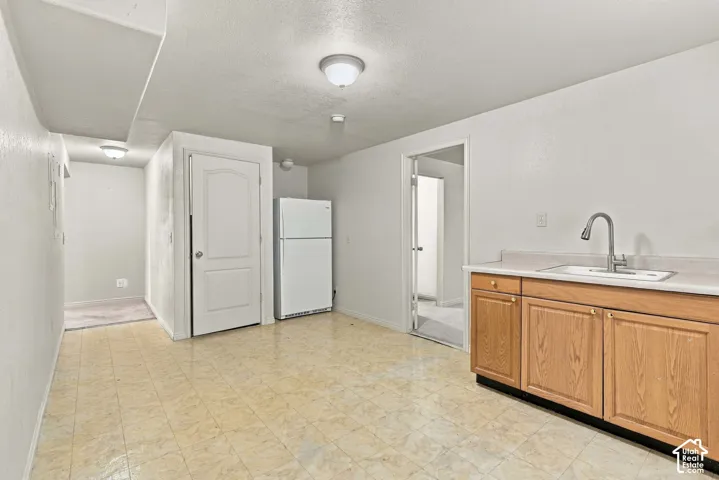Neutral-toned tile flooring throughout, featuring a built-in cabinetry with a sink and a gooseneck faucet