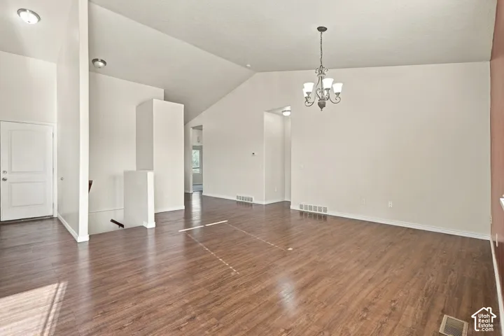 Vaulted ceiling, wood-finish flooring, chandelier, two-panel interior door, recessed lighting