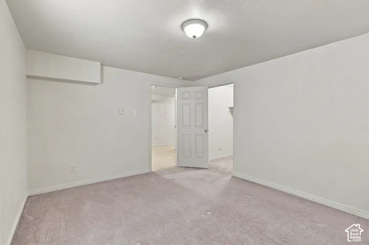 Wall-to-wall carpeting with ceiling-mounted light fixture, and white painted walls