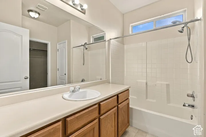 Vanity with wood-finish cabinetry, integrated sink, and extended countertop