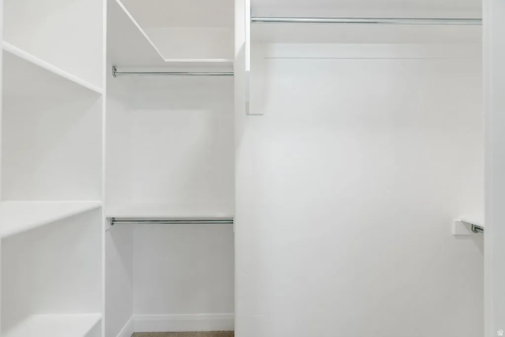 Built-in shelving, white painted walls, and chrome hanging rods