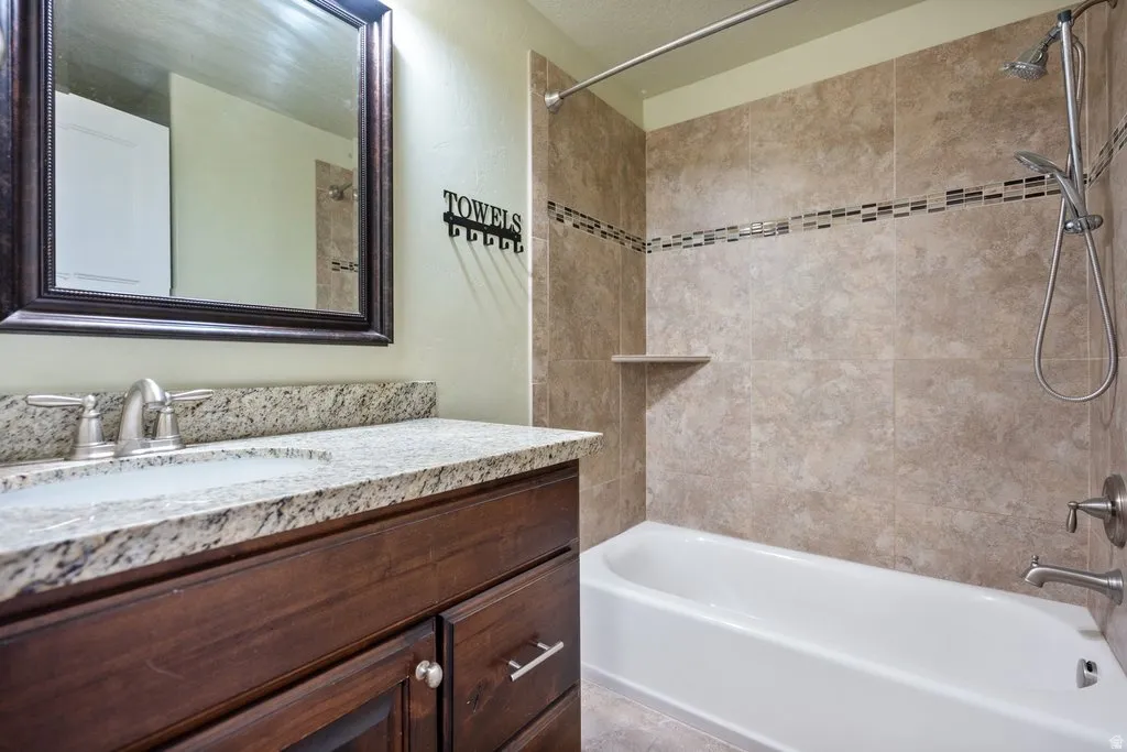 Granite-style countertop with an undermount sink, dark wood-finish vanity, and brushed nickel fixtures