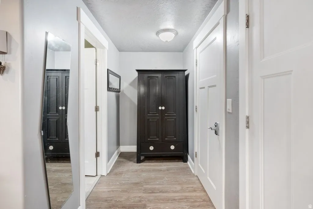 Wood-finish flooring with white trim and a flush-mount ceiling light fixture