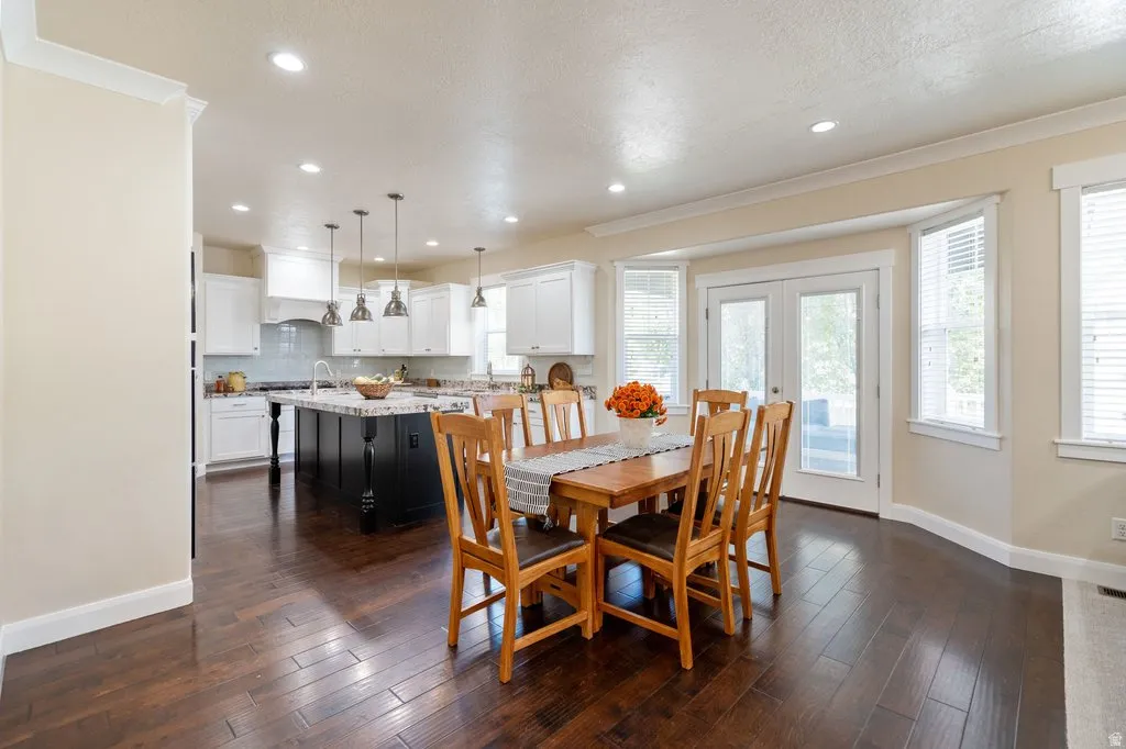 Open-concept space featuring dark wood-finish flooring, recessed lighting, and crown molding