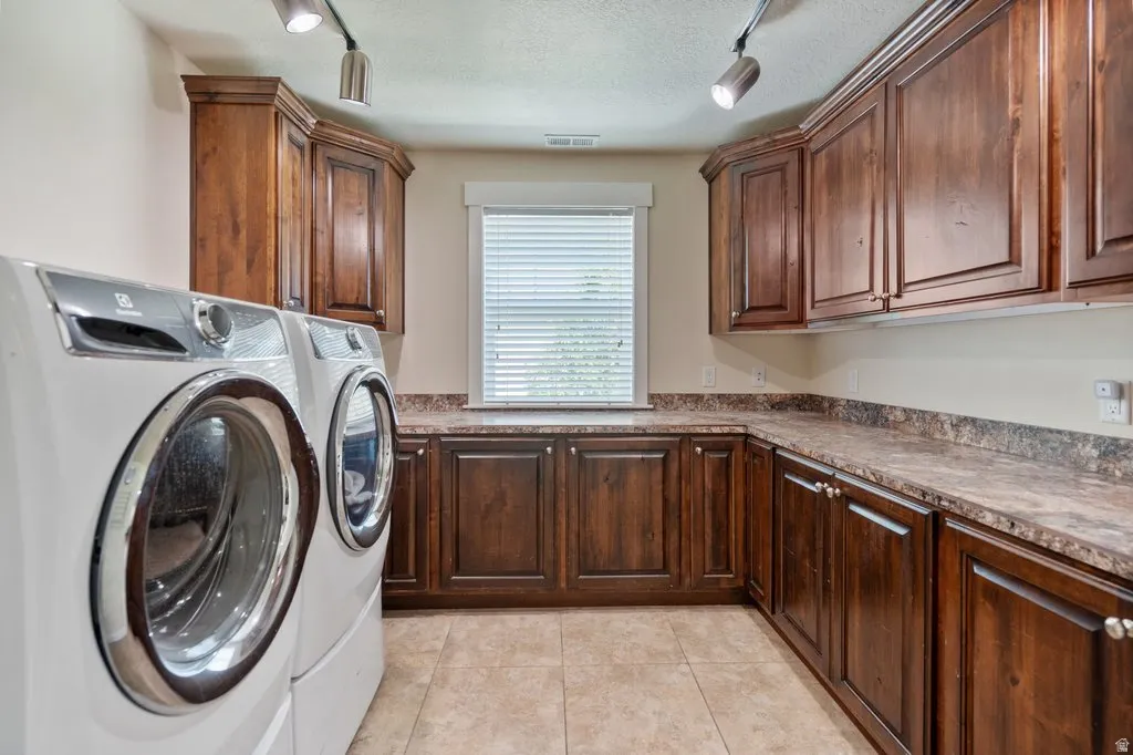 Expansive counter space, extensive wood cabinetry, tiled flooring, and window with blinds