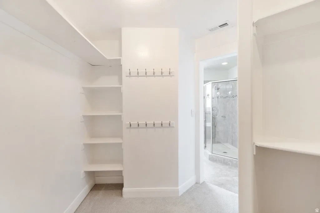 Built-in shelving, wall-mounted hooks, and soft gray carpeting