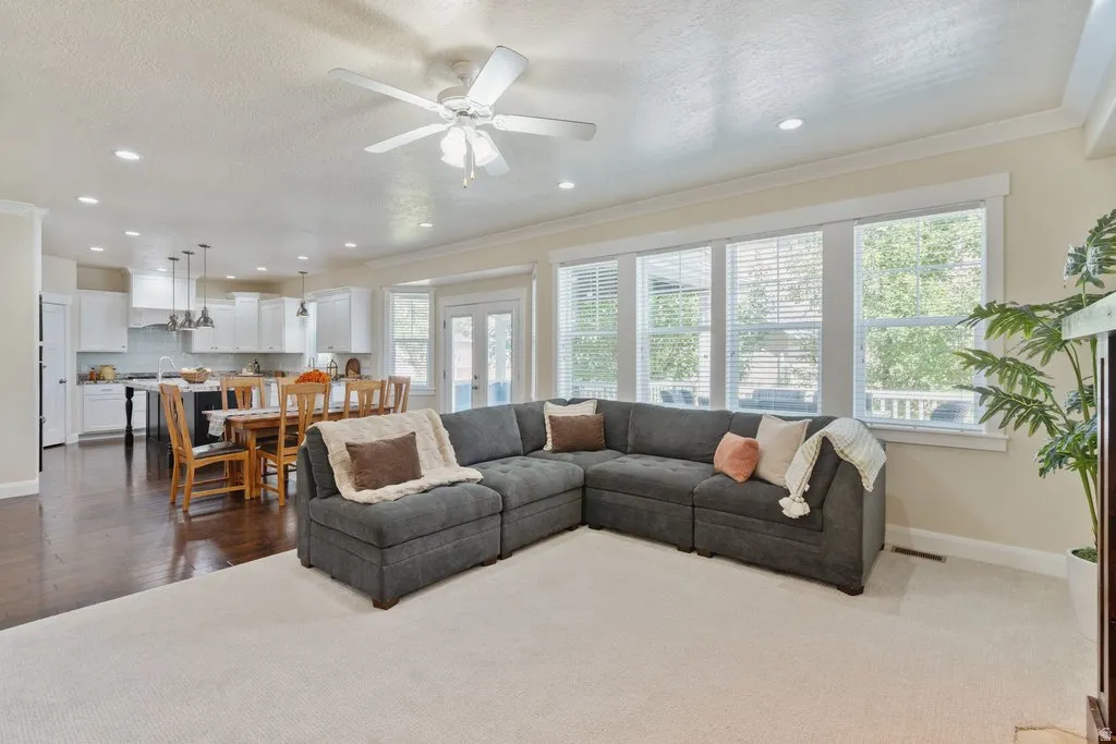 Open-concept living area with recessed lighting, ceiling fan, and large windows
