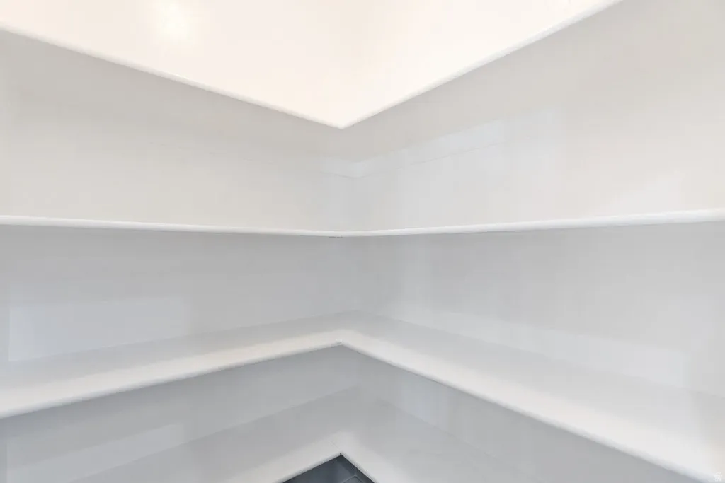 Recessed built-in shelving with multiple levels, white paint finish, and dark flooring