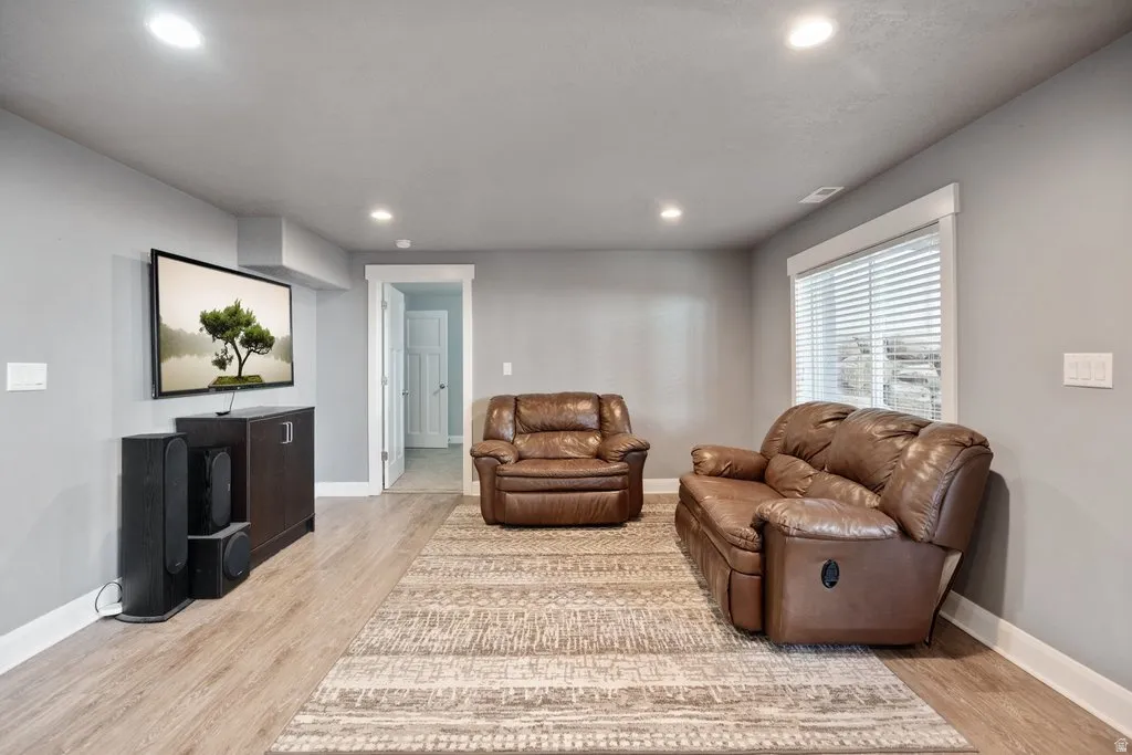 Recessed lighting, wood-finish flooring, white window trim, and white baseboards