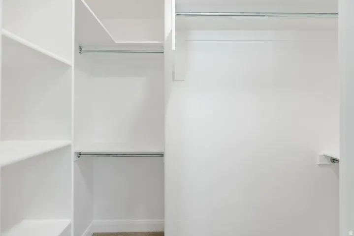 Built-in shelving, white painted walls, and chrome hanging rods
