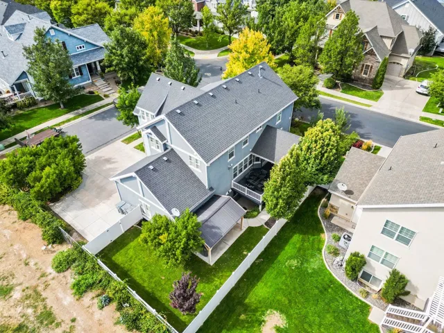 Property featuring a multi-level exterior, an attached rear deck, an expansive backyard with a manicured lawn, a covered patio, and mature landscaping