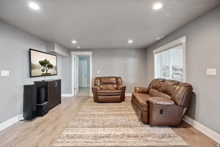 Recessed lighting, wood-finish flooring, white window trim, and white baseboards