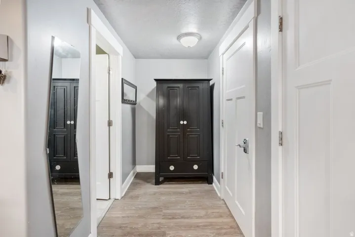 Wood-finish flooring with white trim and a flush-mount ceiling light fixture