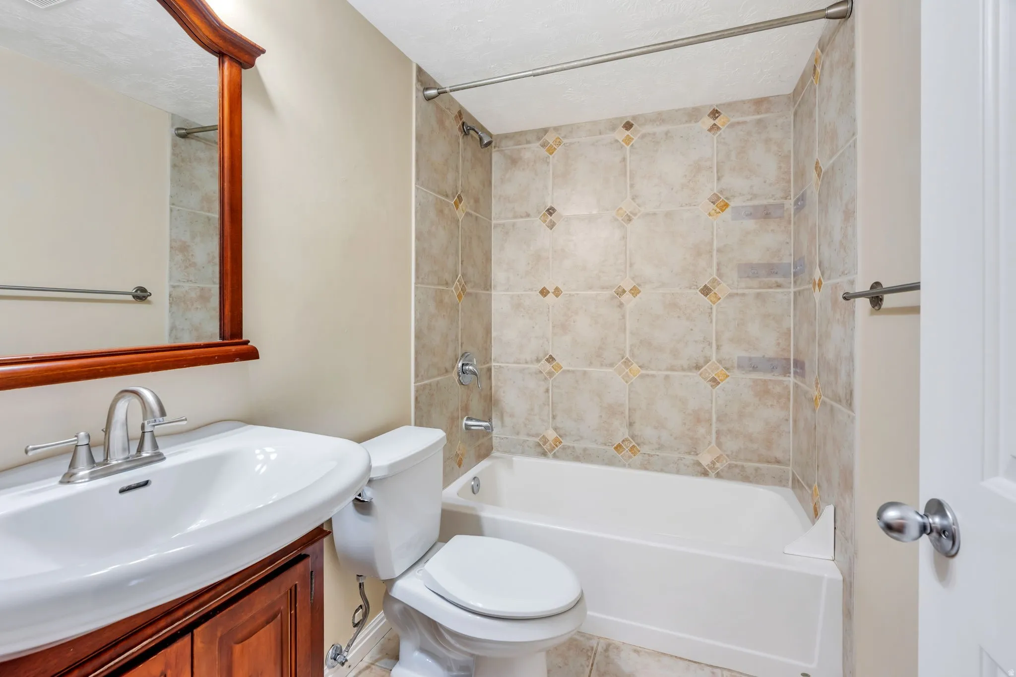 Bathroom featuring a white vanity with an integrated sink, brushed nickel faucet, and a wood-framed mirror