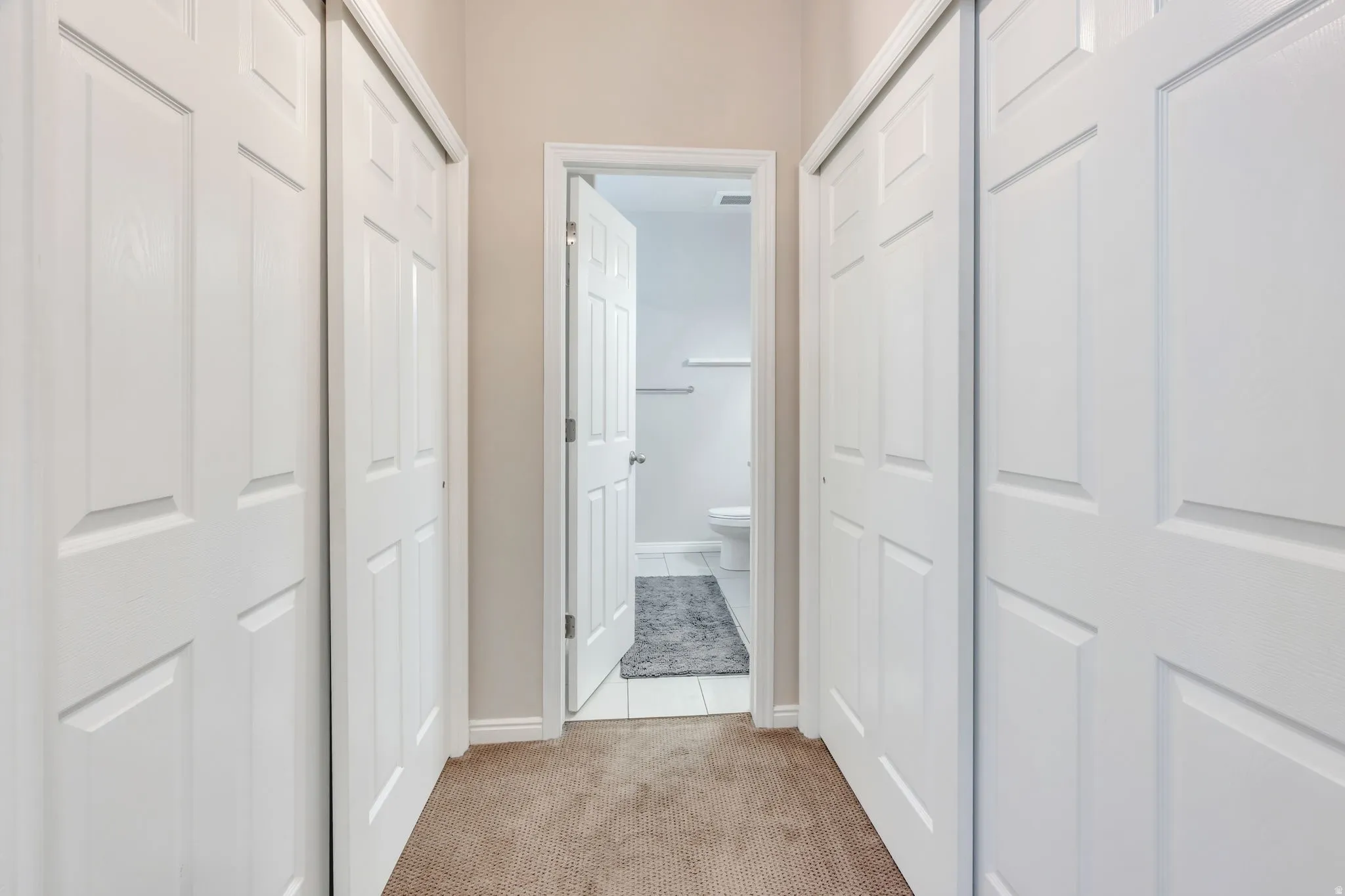 Hallway with neutral carpet flooring and white paneled doors