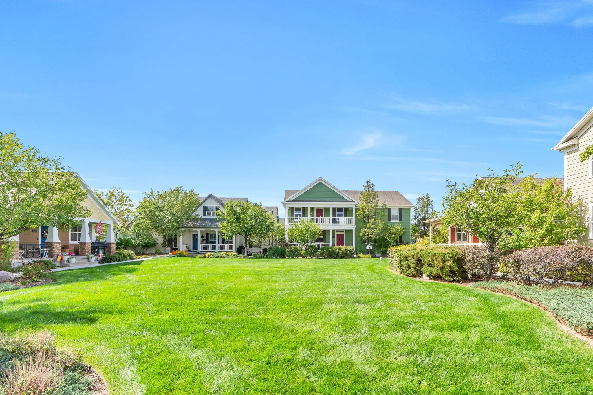 Expansive green space with manicured lawn and established landscaping