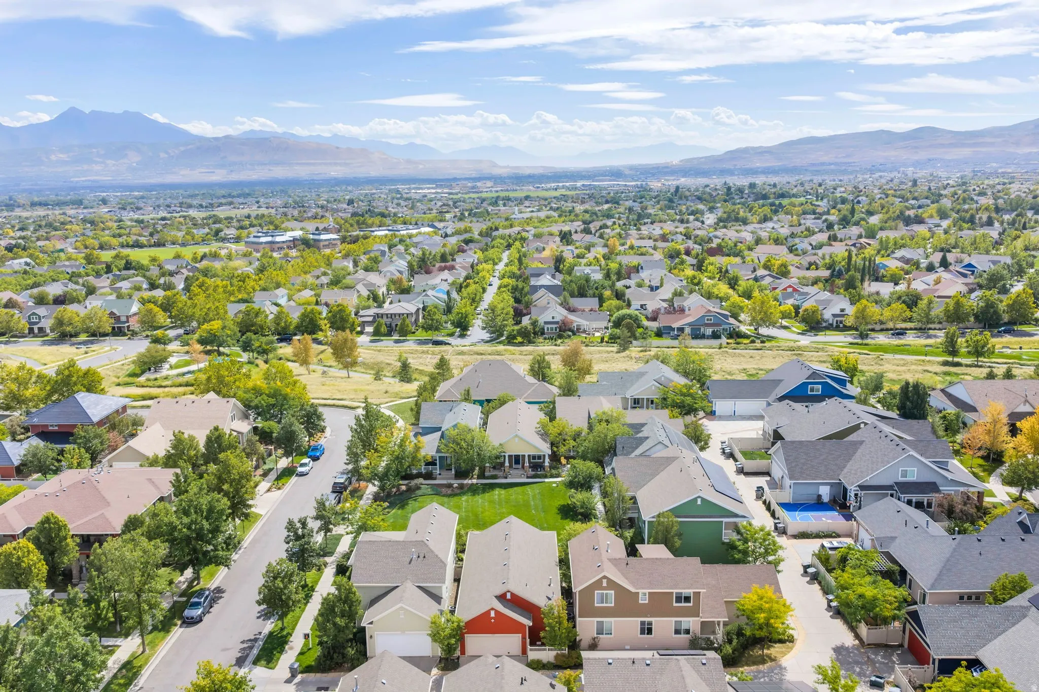 Residential neighborhood with established streets and mature trees, featuring a mountain backdrop and varied architectural styles