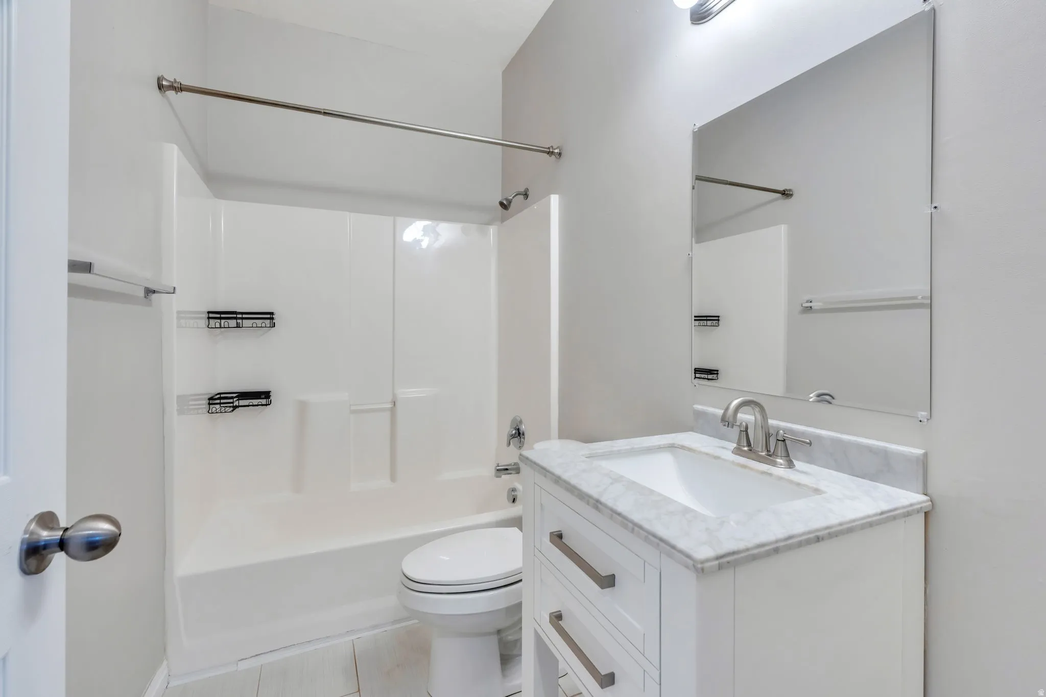 White vanity with a marble-finish countertop, undermount sink, and brushed nickel faucet
