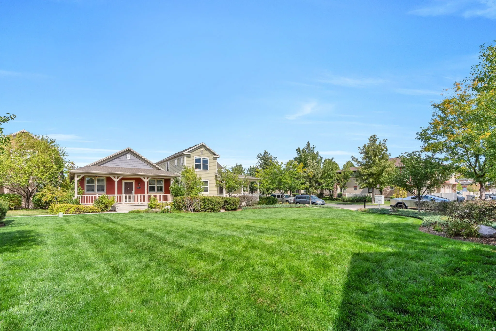 Expansive green space with mature trees, bordered by residential architecture