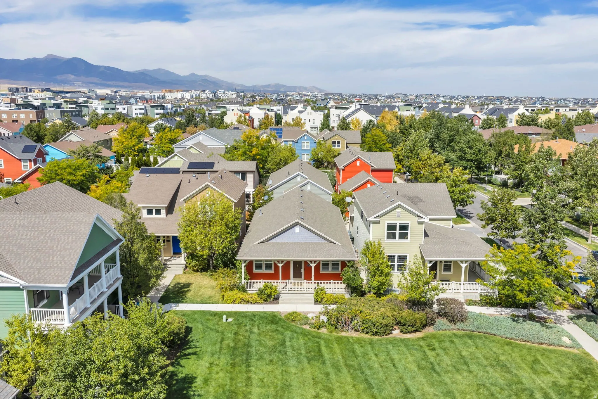 Expansive community with varied architectural styles, manicured green spaces, and mature landscaping