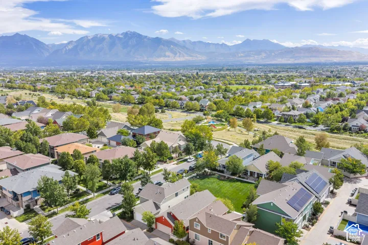 Residential neighborhood with mountain scenery, green spaces, and solar panel installations