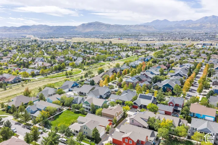 Residential neighborhood with varied architectural styles, mature trees, and mountainous background