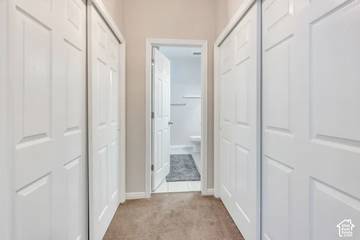 Hallway with neutral carpet flooring and white paneled doors