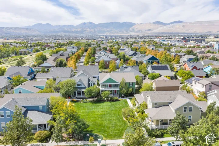 Residential community with a variety of architectural styles, mature trees, mountain backdrop, and green spaces