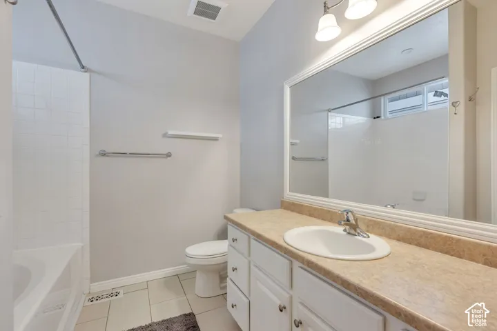 Bathroom with a single vanity, white cabinetry, integrated sink, and a large wall-mounted mirror
