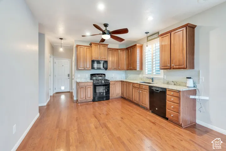 Kitchen featuring wood-finish flooring, recessed lighting, wood cabinetry, stone countertops, and a ceiling fan