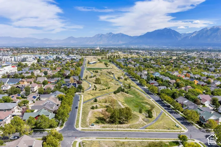 Aerial perspective showcasing a residential area with varied housing styles, surrounded by green spaces and paved pathways