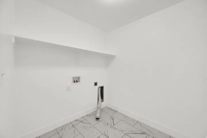 Laundry area with white walls and a built-in white shelf