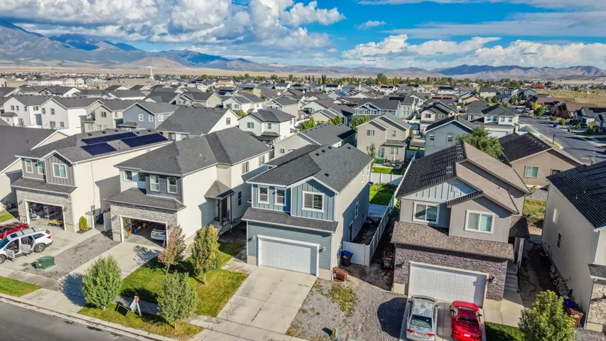 Modern residential architecture with pitched roofs, integrated garages, and varied exterior finishes
