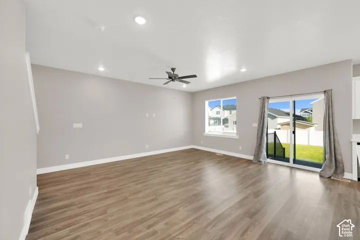 Spacious room with wood-finish flooring, recessed lighting, and a ceiling fan