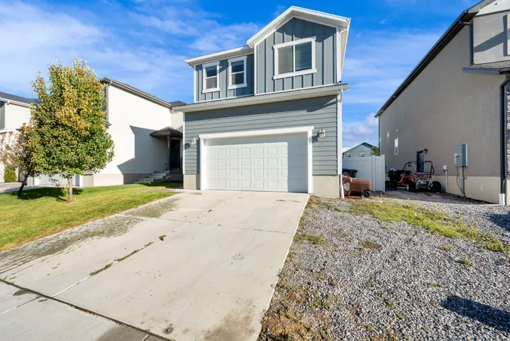 Two-story residence featuring light gray siding, white trim, and an attached two-car garage