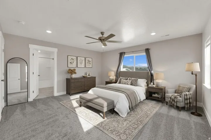 Recessed lighting, ceiling fan, carpet flooring, large window, and an en-suite bathroom featuring a tub/shower combination