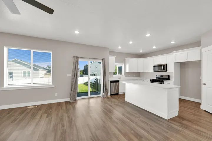 Open-concept living area featuring wood-finish flooring, recessed lighting, and a ceiling fan