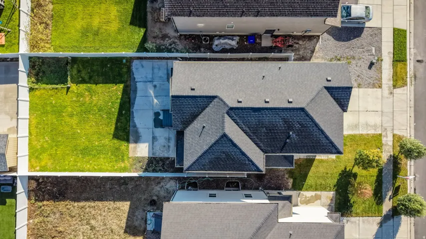 Expansive property featuring a gabled roofline, concrete driveway, and a large lawn area