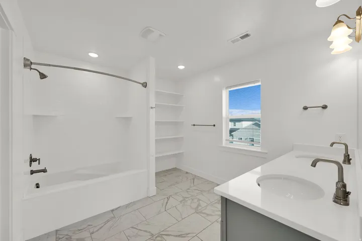 Dual vanity with white countertops, undermount sinks, and bronze-finish faucets