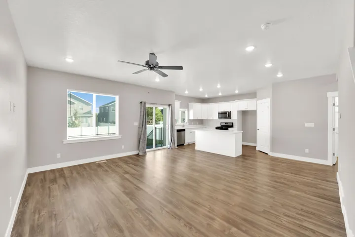 Open-concept living area featuring wood-finish flooring, recessed lighting, and a ceiling fan