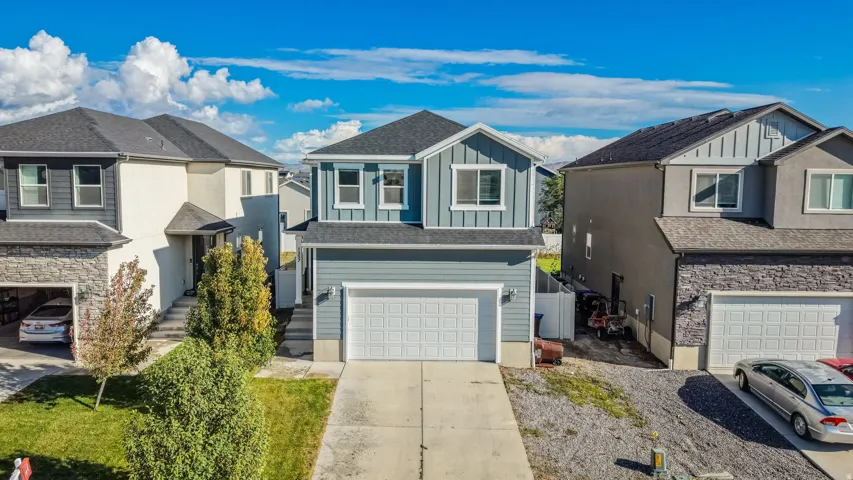 Two-story exterior with a contrasting façade, attached garage, and a concrete driveway